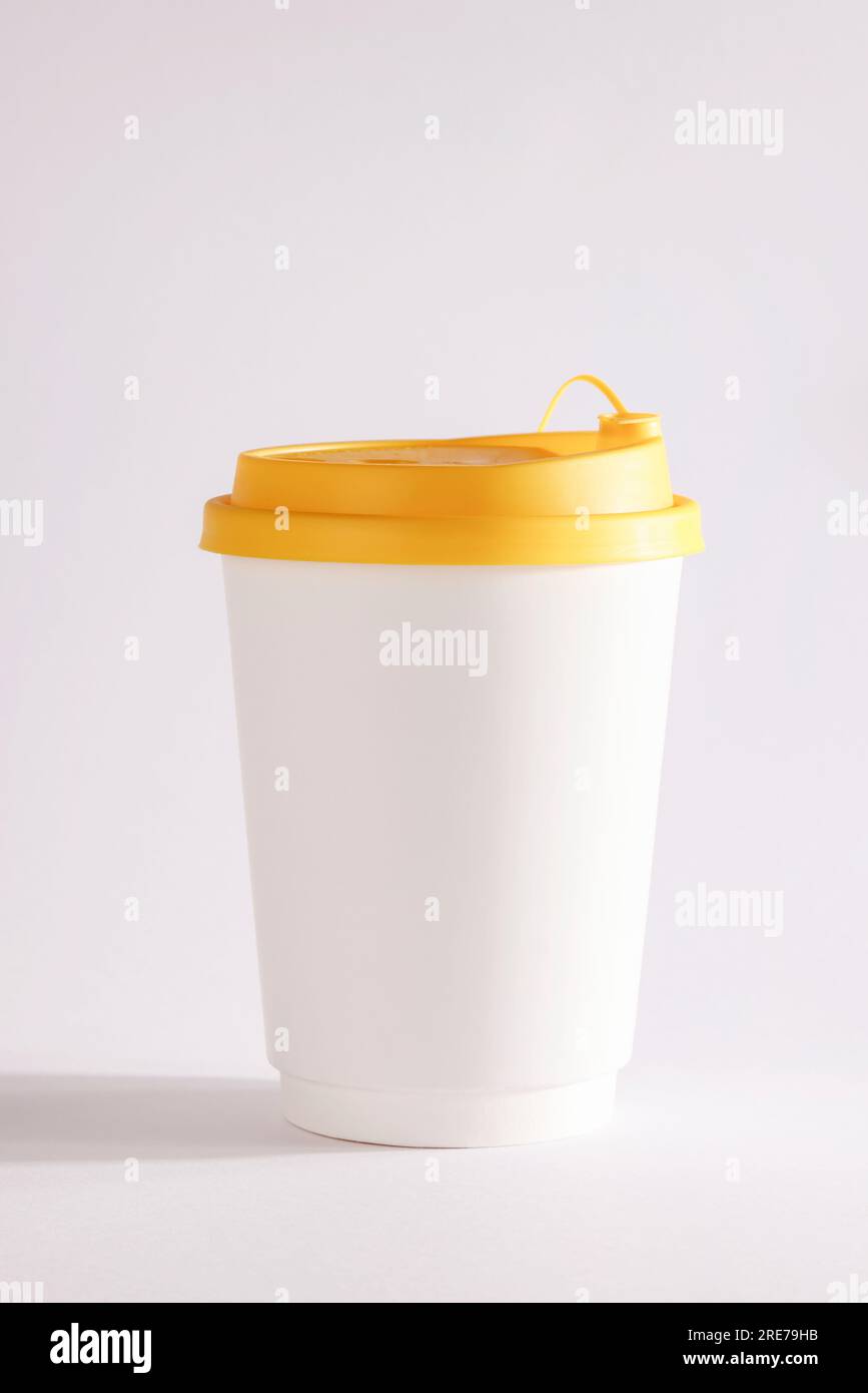 Tasse blanche de recyclage de papier à emporter avec couvercle jaune sur fond blanc , maquette , modèle, espace pour votre texte , publicité. Banque D'Images