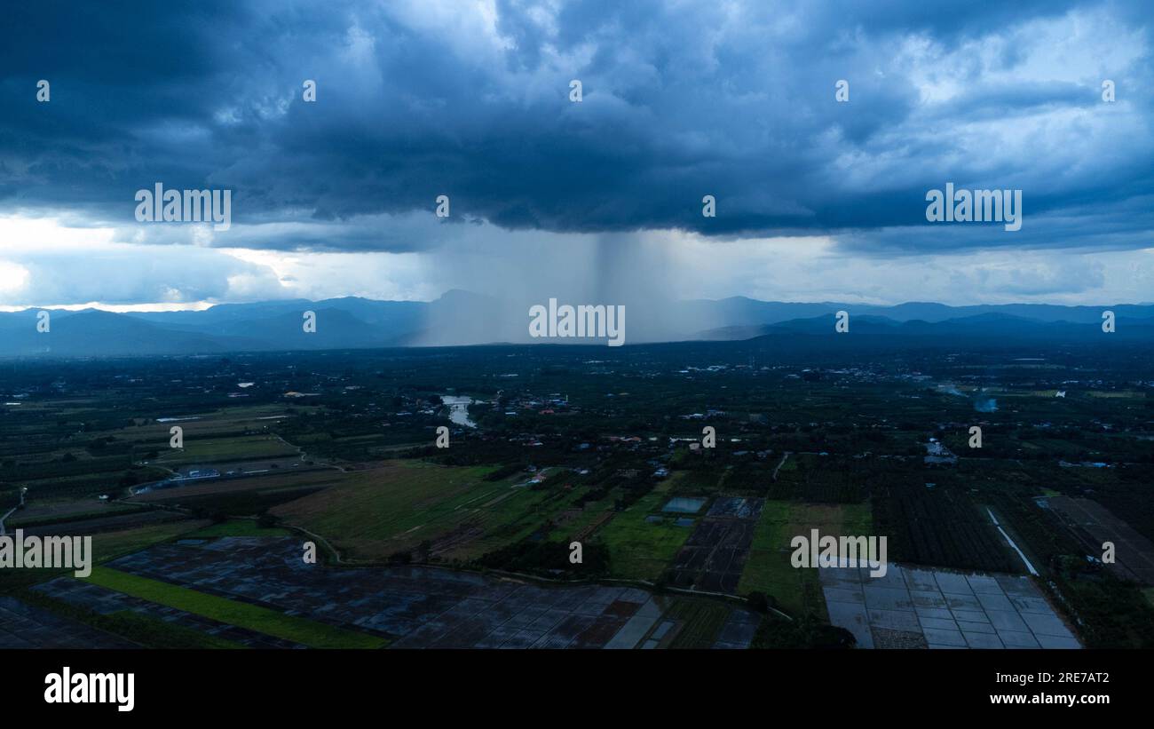 Vue panoramique aérienne de la communauté et des terres agricoles avec d'énormes nuages de tempête en arrière-plan. Vue aérienne de la pluie au-dessus d'une communauté rurale. Nuages de pluie Banque D'Images