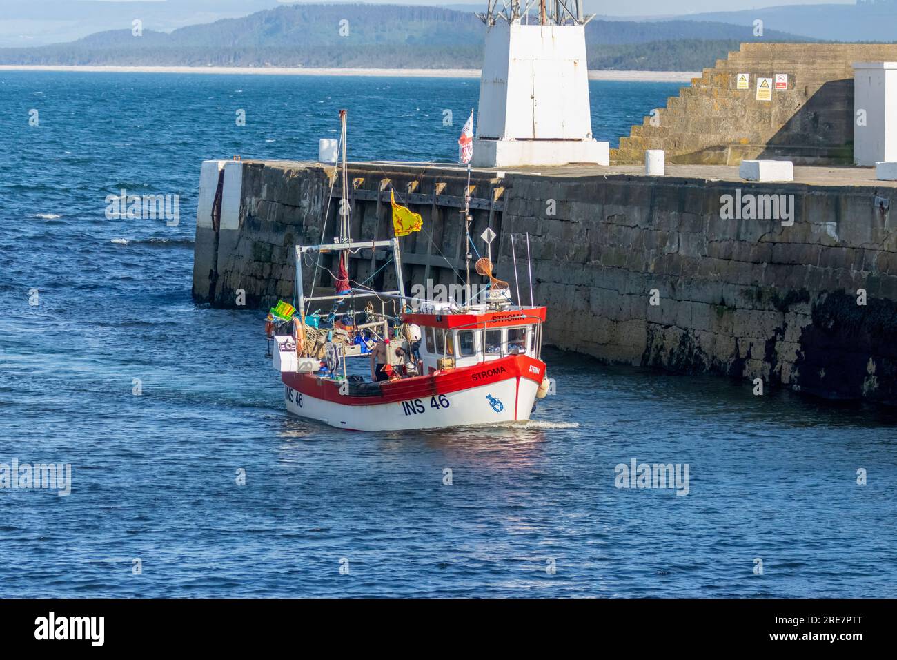 Bateau de pêche rouge et blanc revenant dans le port après une journée en mer Banque D'Images