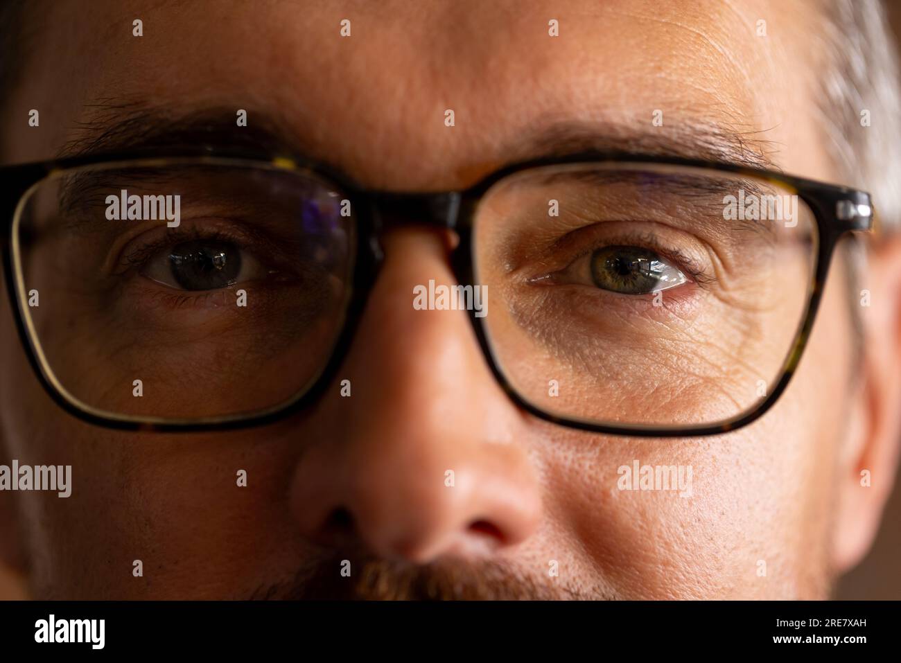 Gros plan des yeux d'un homme d'affaires caucasien portant des lunettes au bureau Banque D'Images
