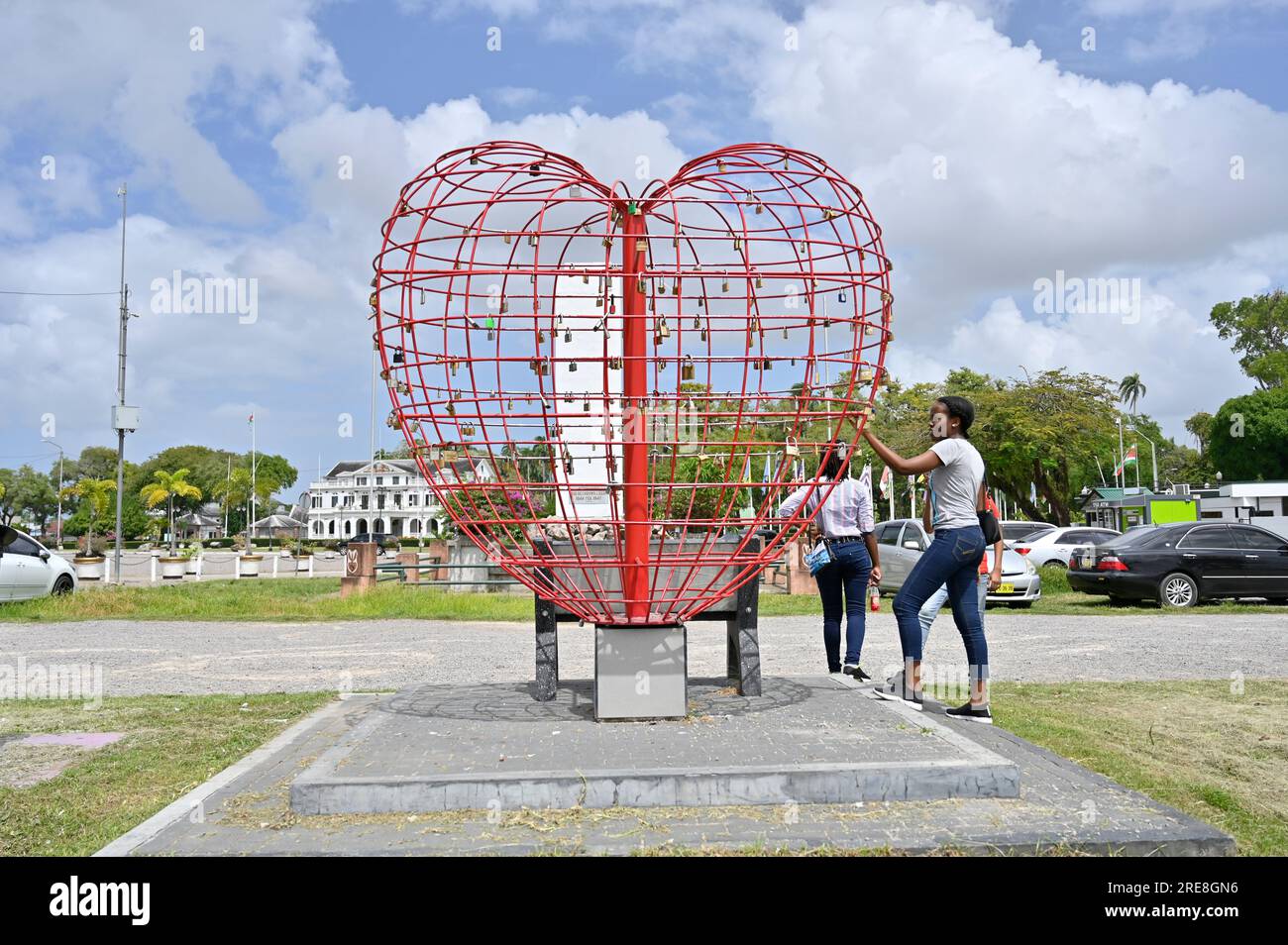Heart of Love Heart est une œuvre d'art à Paramaribo, Surinam. Il est destiné aux amoureux d'accrocher un verrou d'amour. Une jeune fille y regarde de près. Banque D'Images