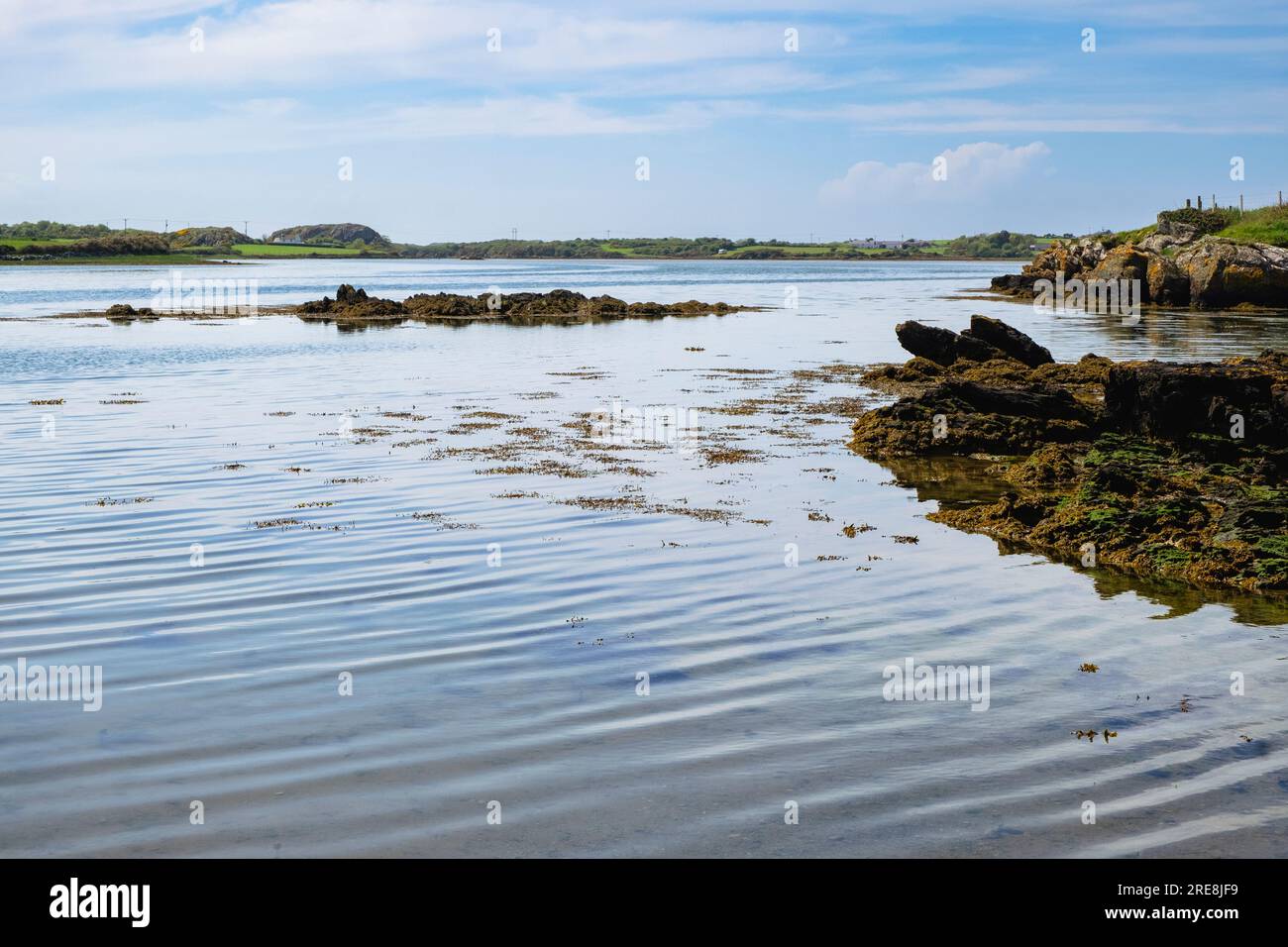Vue sur l'eau calme et tranquille dans la mer intérieure à marée haute près de four Mile Bridge, Caergeiliog, île d'Anglesey, pays de Galles, Royaume-Uni, Grande-Bretagne Banque D'Images