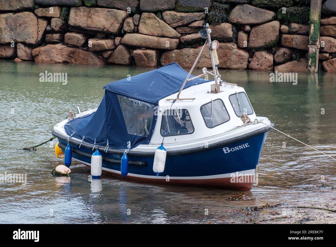 Petit bateau bleu et blanc nommé Bonnie amarré dans le port de Mousehole à marée basse. Mousehole, Penzance, Cornouailles, Angleterre. Banque D'Images