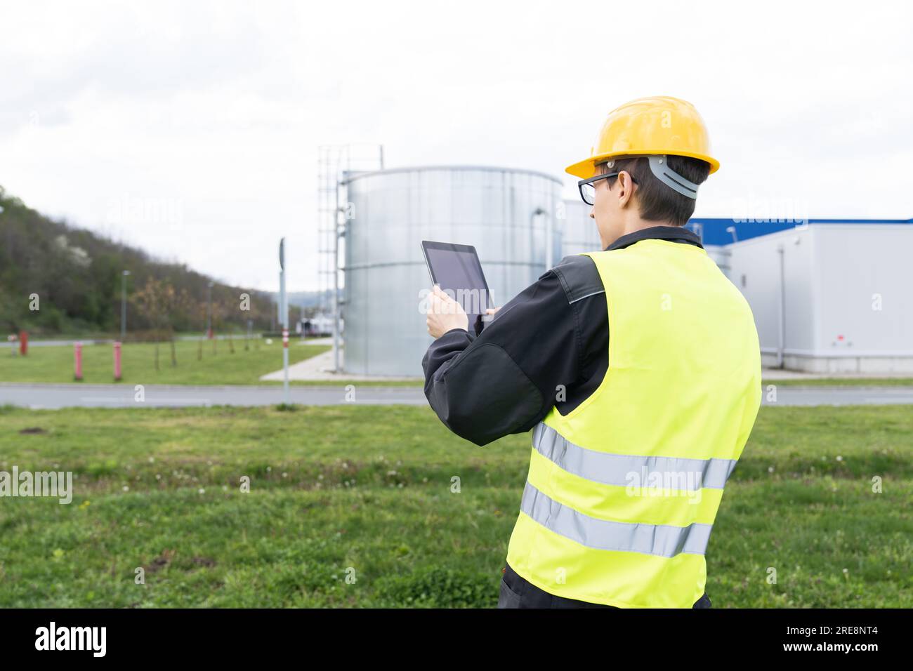 Concevoir avec une tablette numérique sur un fond de réservoirs de gaz. Banque D'Images