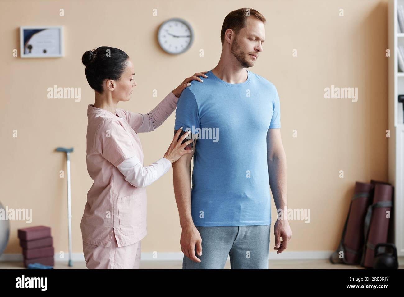 Thérapeute professionnel examinant l'épaule et le dos d'un patient à l'hôpital Banque D'Images