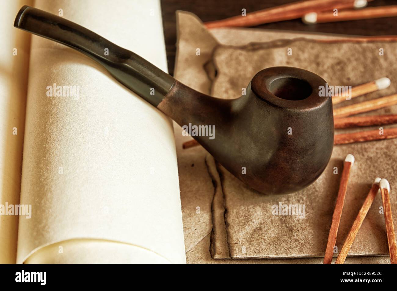 Pipe à fumer avec du tabac et allumettes sur le tube de pergament. Équipement vintage Gentleman Banque D'Images