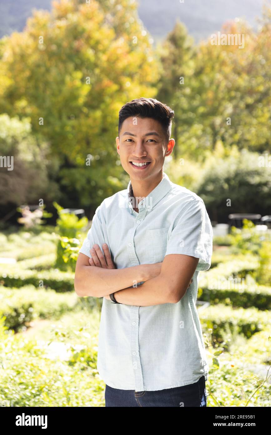 Portrait d'homme asiatique heureux souriant dans le jardin ensoleillé Banque D'Images