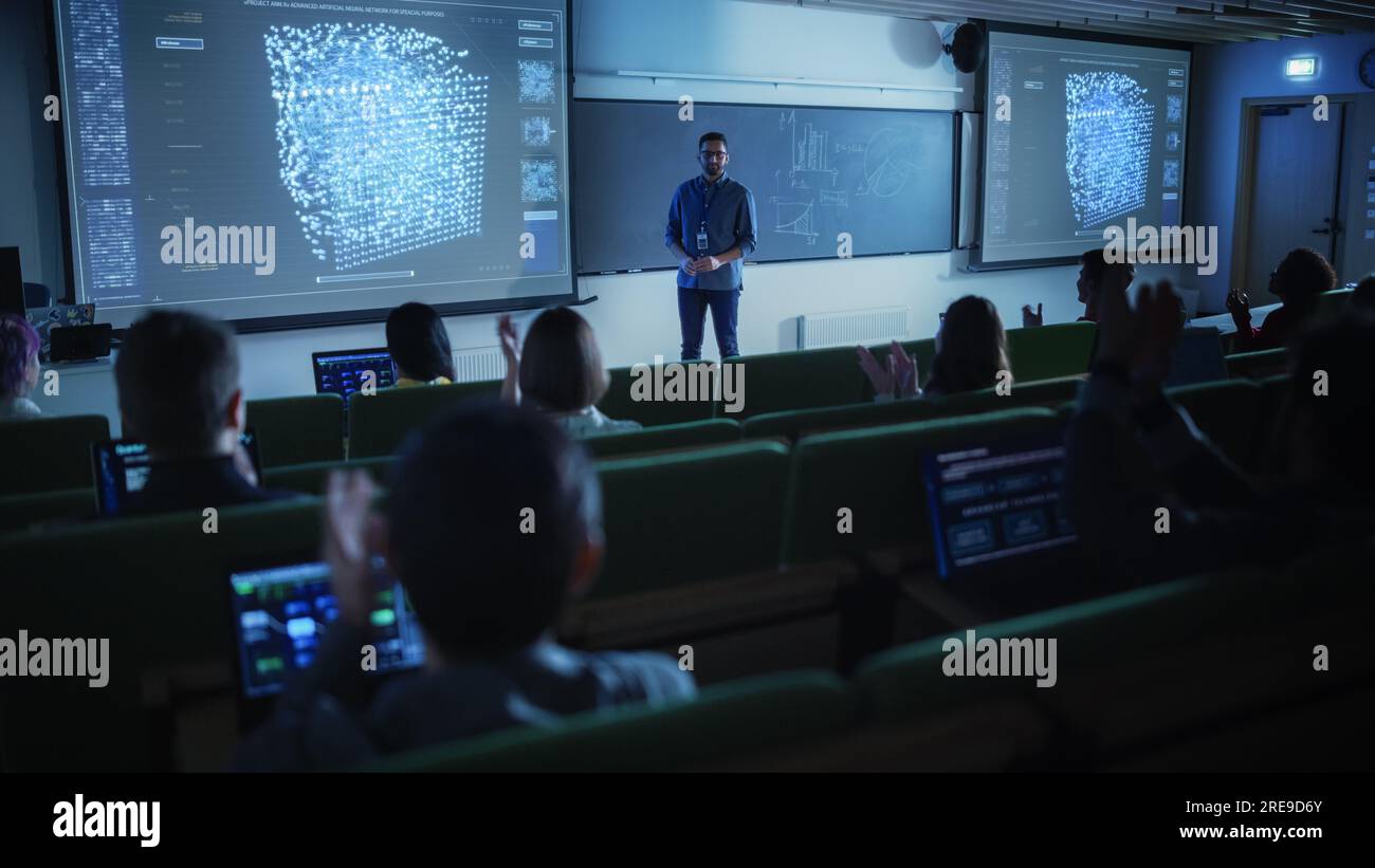 Jeune enseignant masculin donnant une conférence sur la science des données à un groupe multiethnique diversifié d'étudiants féminins et masculins dans un espace universitaire sombre. Projection de diapositives Banque D'Images