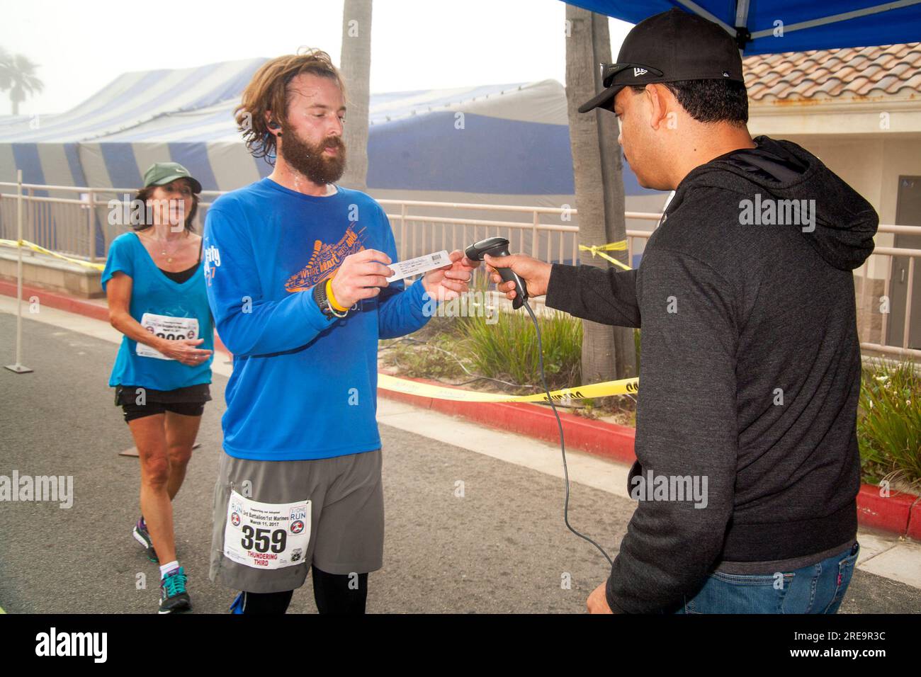 19 juin 2017 : à la fin d'une course à pied à Huntington Beach, CA, un coureur barbu affiche son code barre de classification pour enregistrer son temps de course officiel. Notez le lecteur de codes à barres. (Image de crédit : © Spencer Grant/ZUMA Press Wire) USAGE ÉDITORIAL SEULEMENT! Non destiné à UN USAGE commercial ! Banque D'Images