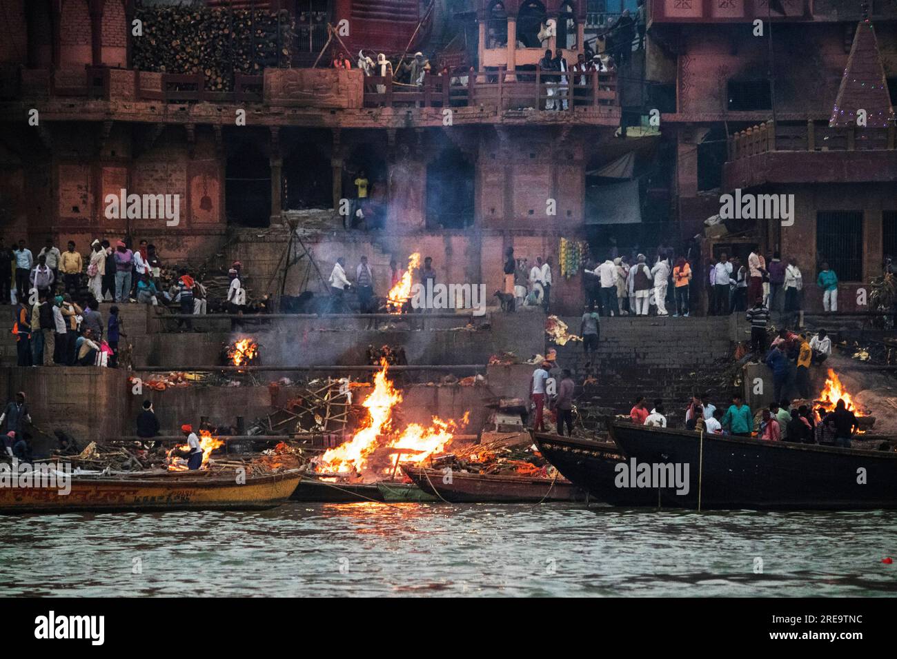 Les gens préparent des bûchers funéraires à Varanasi sur les rives du Gange, qui est l'une des plus anciennes villes continuellement habitées dans le monde, et la plus sainte des sept villes sacrées de l'hindouisme. Chaque jour, à Manikarnika Ghat, le ghat de crémation le plus grand et le plus propice, environ 100 corps sont incinérés sur des bûchers en bois le long du bord de la rivière. On dit que la flamme éternelle qui alimente les feux brûle depuis des siècles maintenant. Varanasi, Inde. Banque D'Images