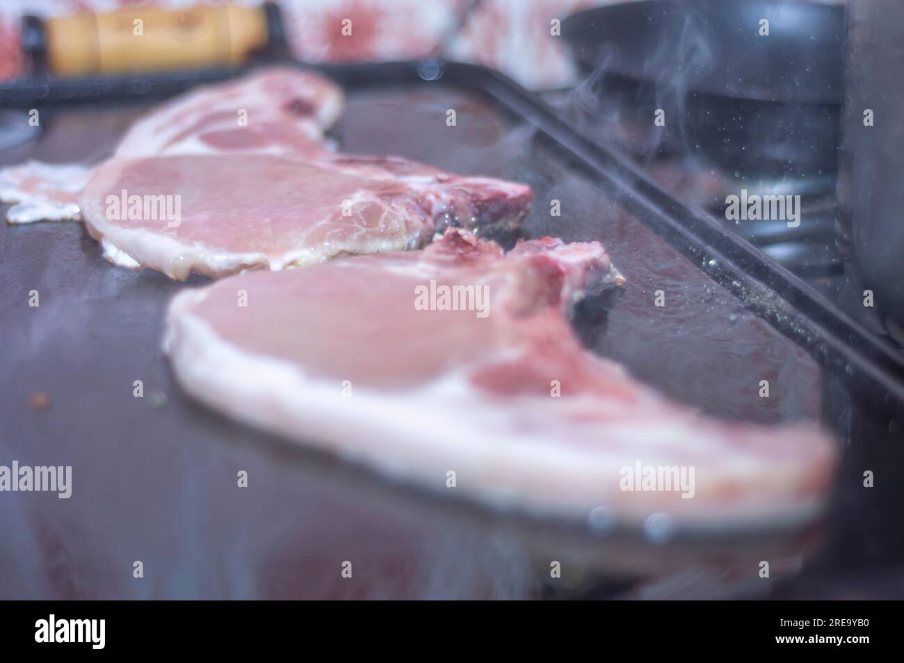 Steak de porc sur un barbecue maison qui est sur le dessus d'un poêle, concept de faire de la nourriture à la maison. Banque D'Images