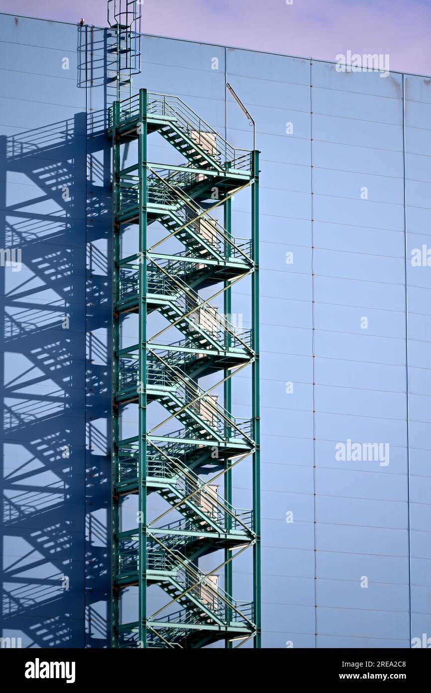 Motif abstrait d'escaliers en zigzag et d'ombres sur le côté d'un bâtiment bleu Banque D'Images