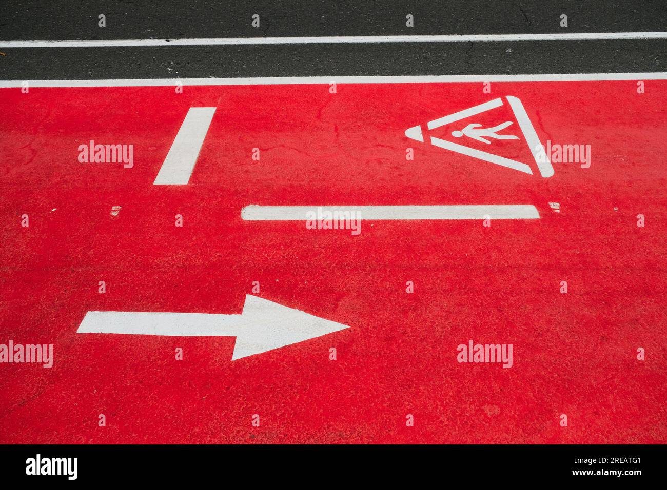 Piste cyclable dans la ville marquée avec le symbole d'avertissement piéton dans le pochoir. Banque D'Images
