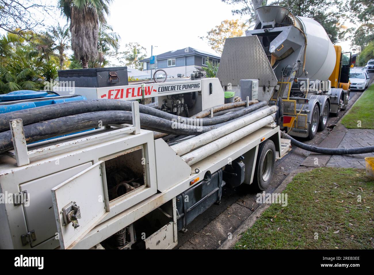Sydney Australie READY MIX béton camion pointe le béton dans la pompe à béton pour bétonner une allée de maison, Australie Banque D'Images