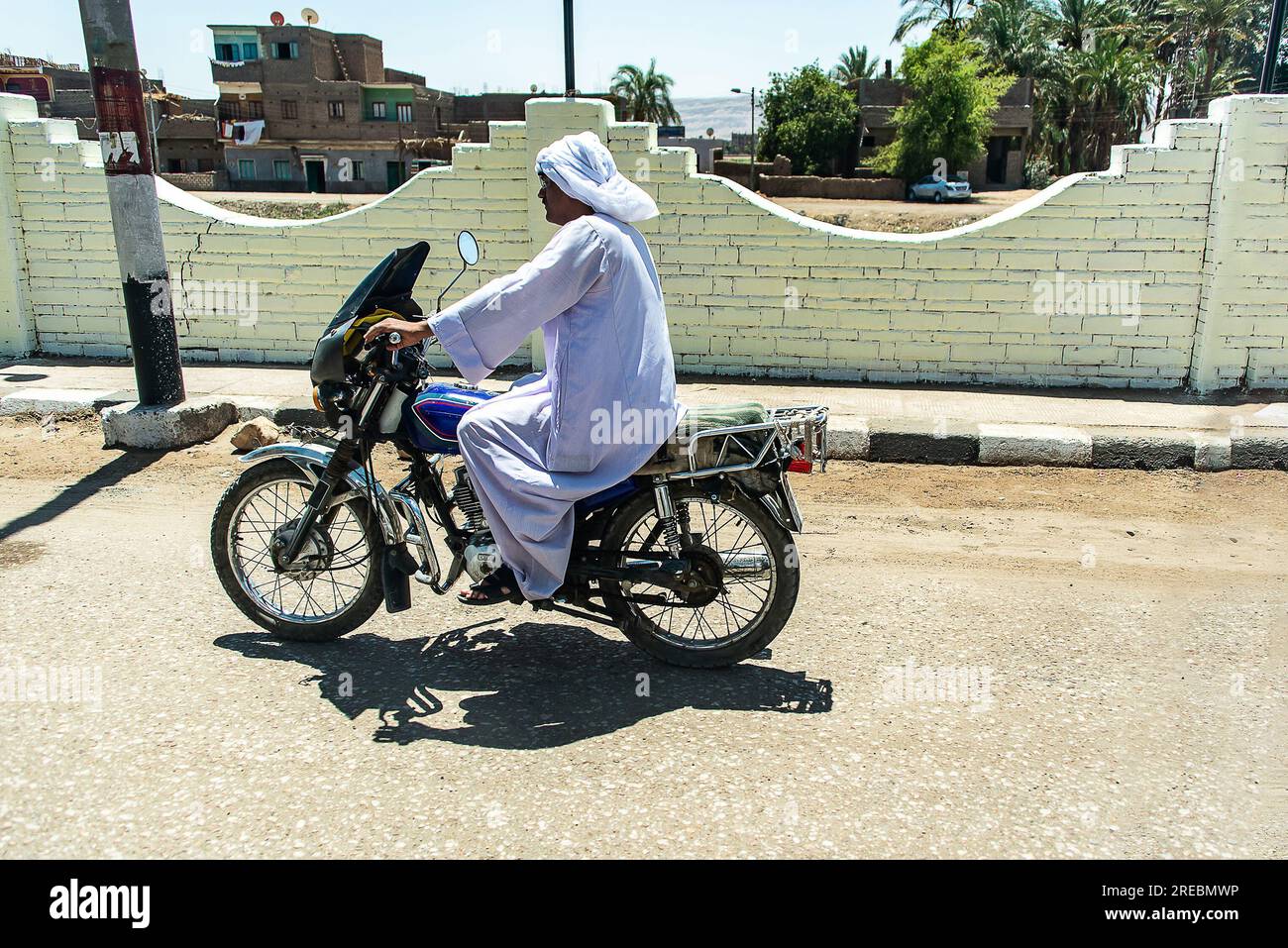 Louxor, Égypte 17.05.2018 vue de la rue de la ville vie quotidienne des gens ordinaires, transport de moto, mur sale. Banque D'Images