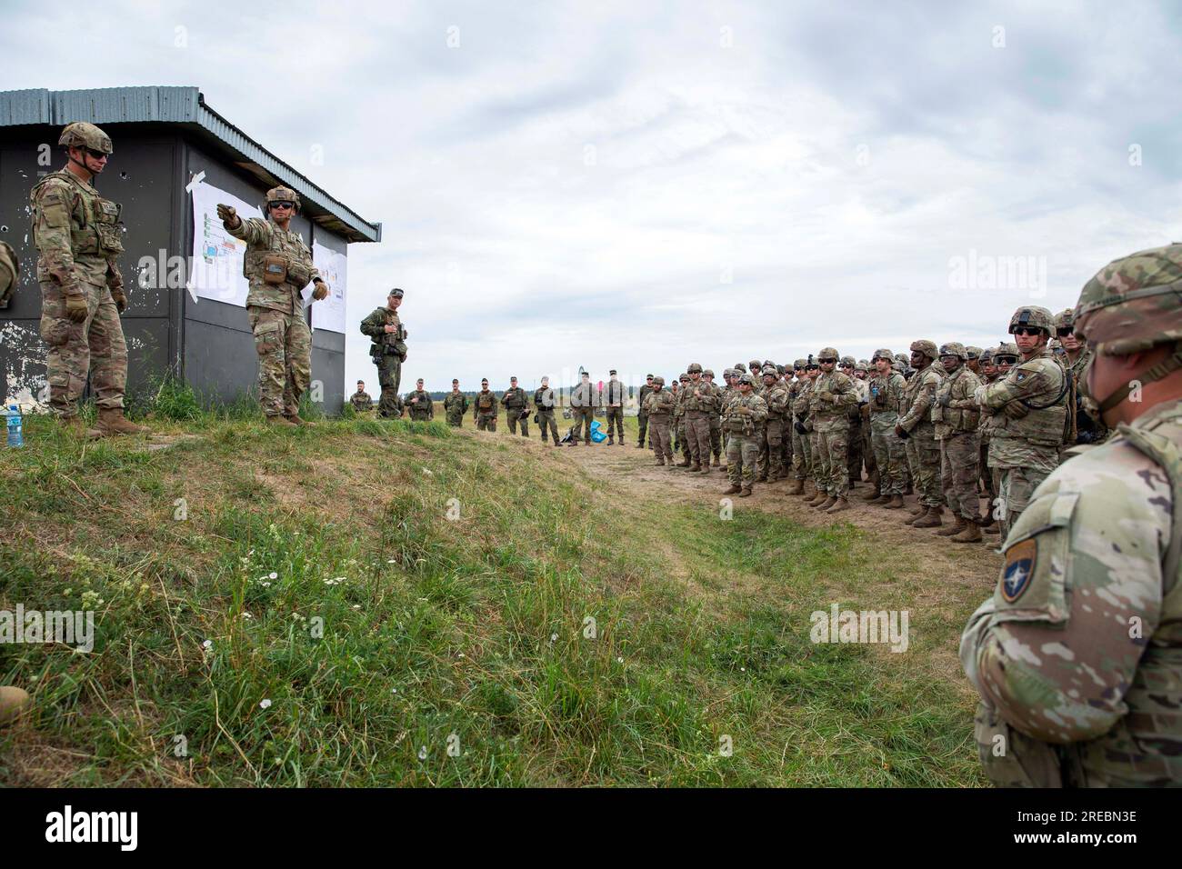 19 juillet 2023 - Pologne - États-Unis Le sergent d'armée de 1e classe Thomas Danies avec la compagnie Alpha, 1e bataillon, 9e régiment de cavalerie, 2e brigade blindée équipe de combat, 1e division de cavalerie, soutenant la 4e division d'infanterie, informe U.S. Soldats de l'armée et soldats de l'armée polonaise avec la Force de défense territoriale des Polands, pendant la formation allemande de qualification des armes à la zone d'entraînement de Bemowo Piskie, Pologne, juillet 18. Cela faisait partie d'une formation allemande de qualification militaire organisée par les membres du groupement tactique de présence avancée renforcée Pologne de l'OTAN. Les soldats ont participé à la formation afin de gagner le German Armed for Banque D'Images