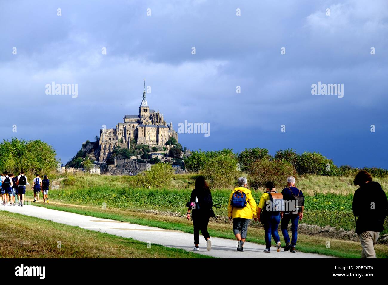 Touristes marchant vers le Mont Saint Michel en Normandie France Banque D'Images