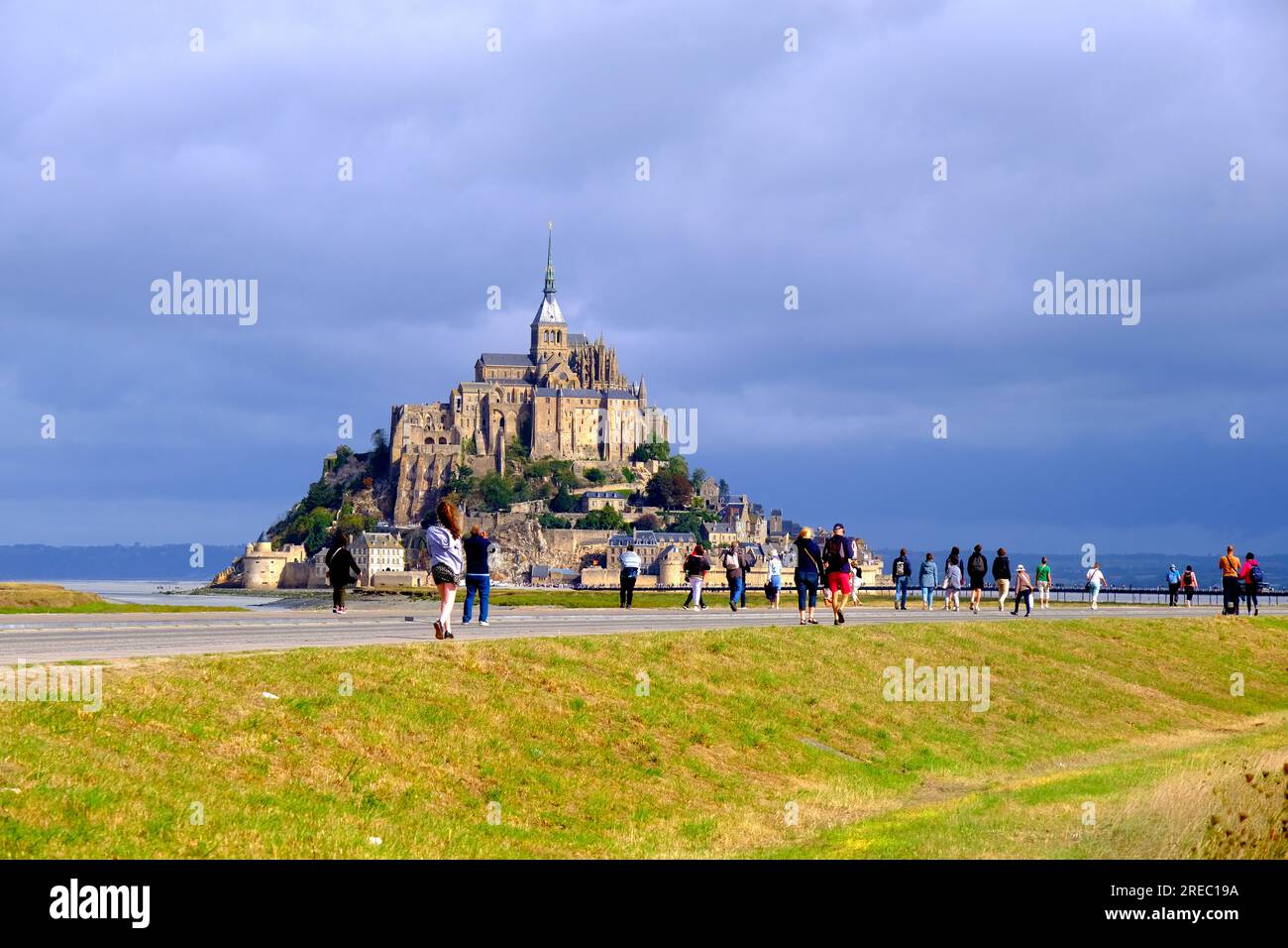 Touristes marchant vers le Mont Saint Michel en Normandie France Banque D'Images