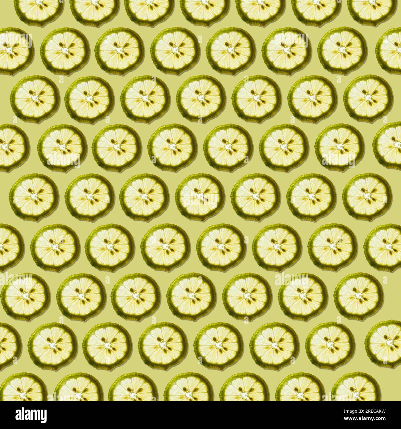 Tranches de citron frais contre vert pâle avec ombre formant un beau fond de motif de texture de papier peint. Banque D'Images
