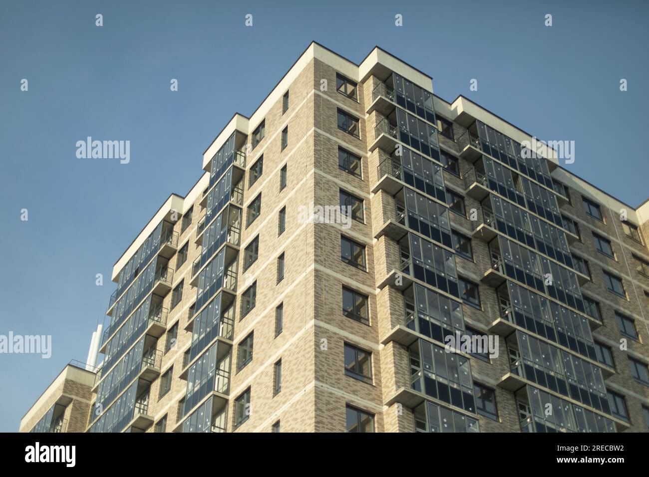 Fenêtres dans le nouveau bâtiment. Immeuble d'appartements en ville. Nouveau boîtier. Balcons vitrés. Banque D'Images