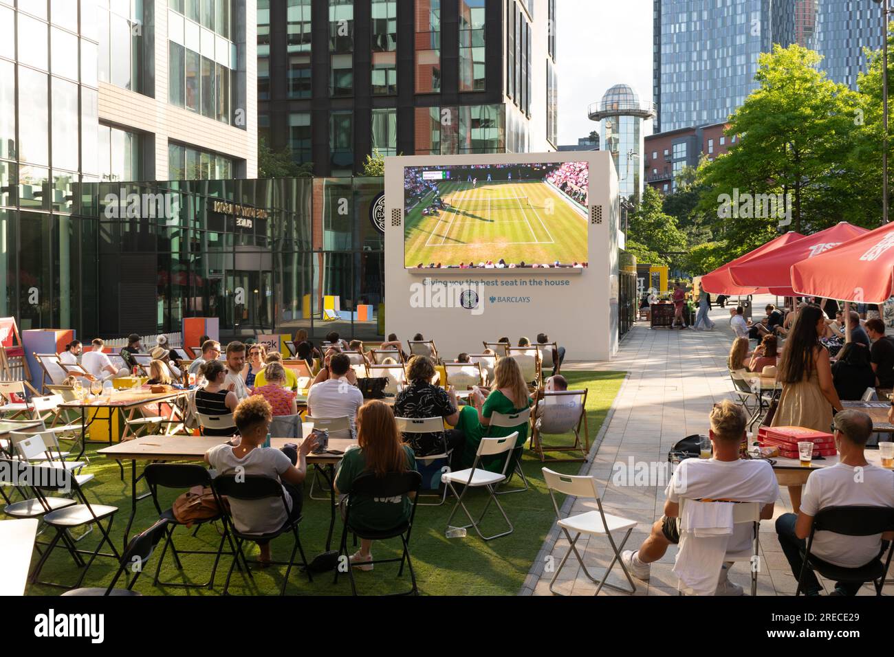 Tony Wilson place. Foule regardant le match de tennis de Wimbledon à l'écran. Les gens étaient assis à des tables à manger et à boire. Manchester UK Banque D'Images