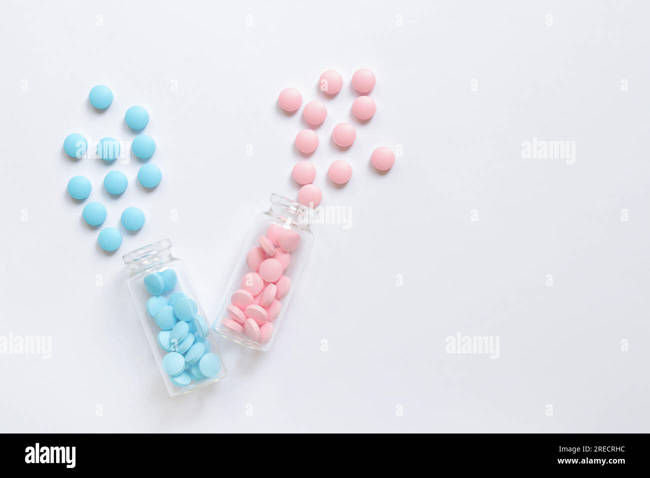 Complexe de vitamines du groupe B, comprimés, complément alimentaire. Un ensemble de pilules bleues et roses dans des bouteilles en verre sur un fond blanc. Soins de santé et douleur Banque D'Images