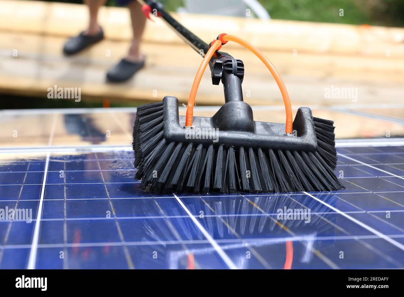 Nettoyage en douceur des modules photovoltaïques avec de l'eau de pluie et une brosse douce Banque D'Images