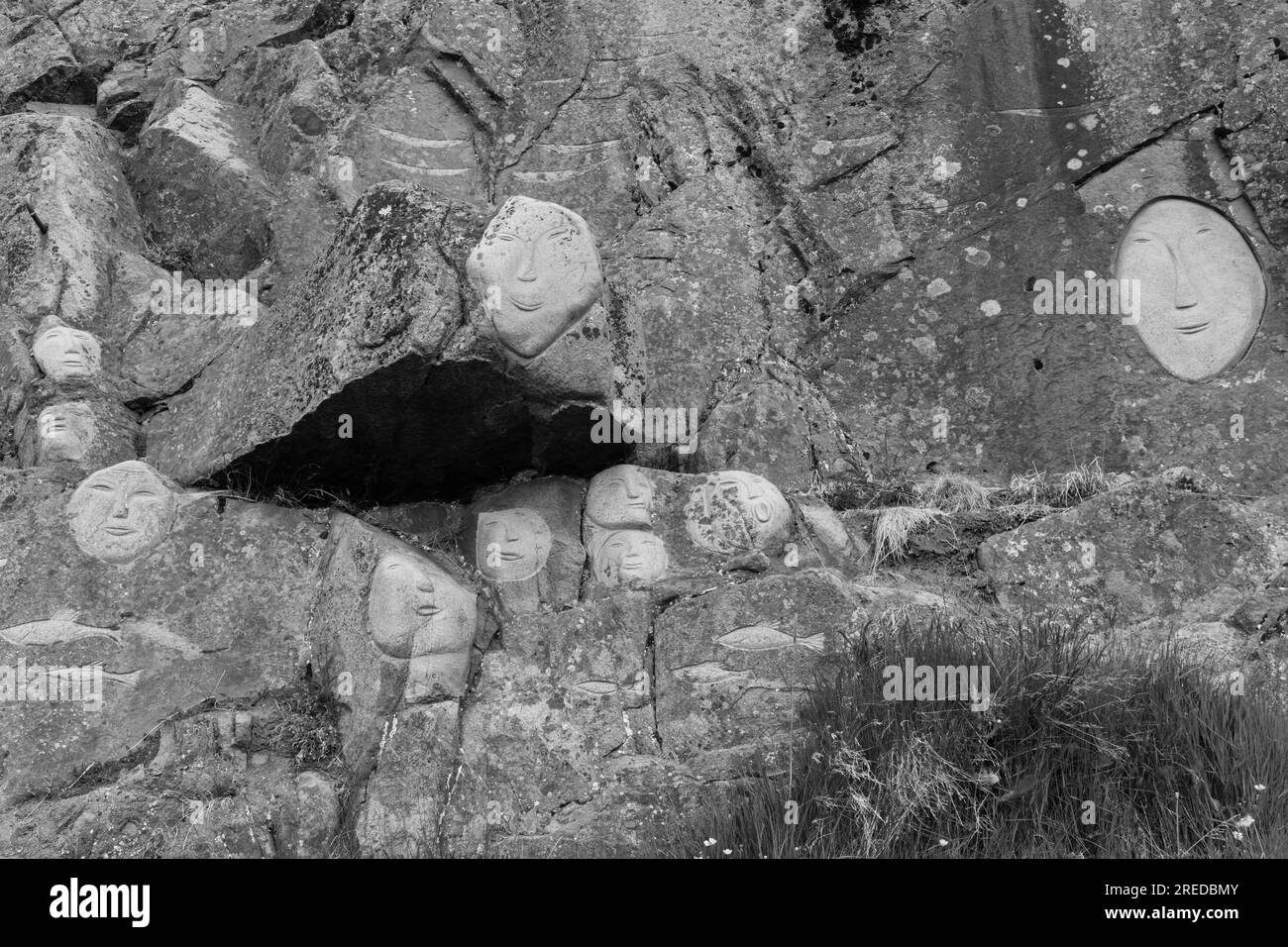 Visages, sculptures rupestres, dans le cadre du projet Stone & Man de l'artiste local aka Høegh à Qaqortoq, Groenland en juillet - monochrome, noir et blanc Banque D'Images