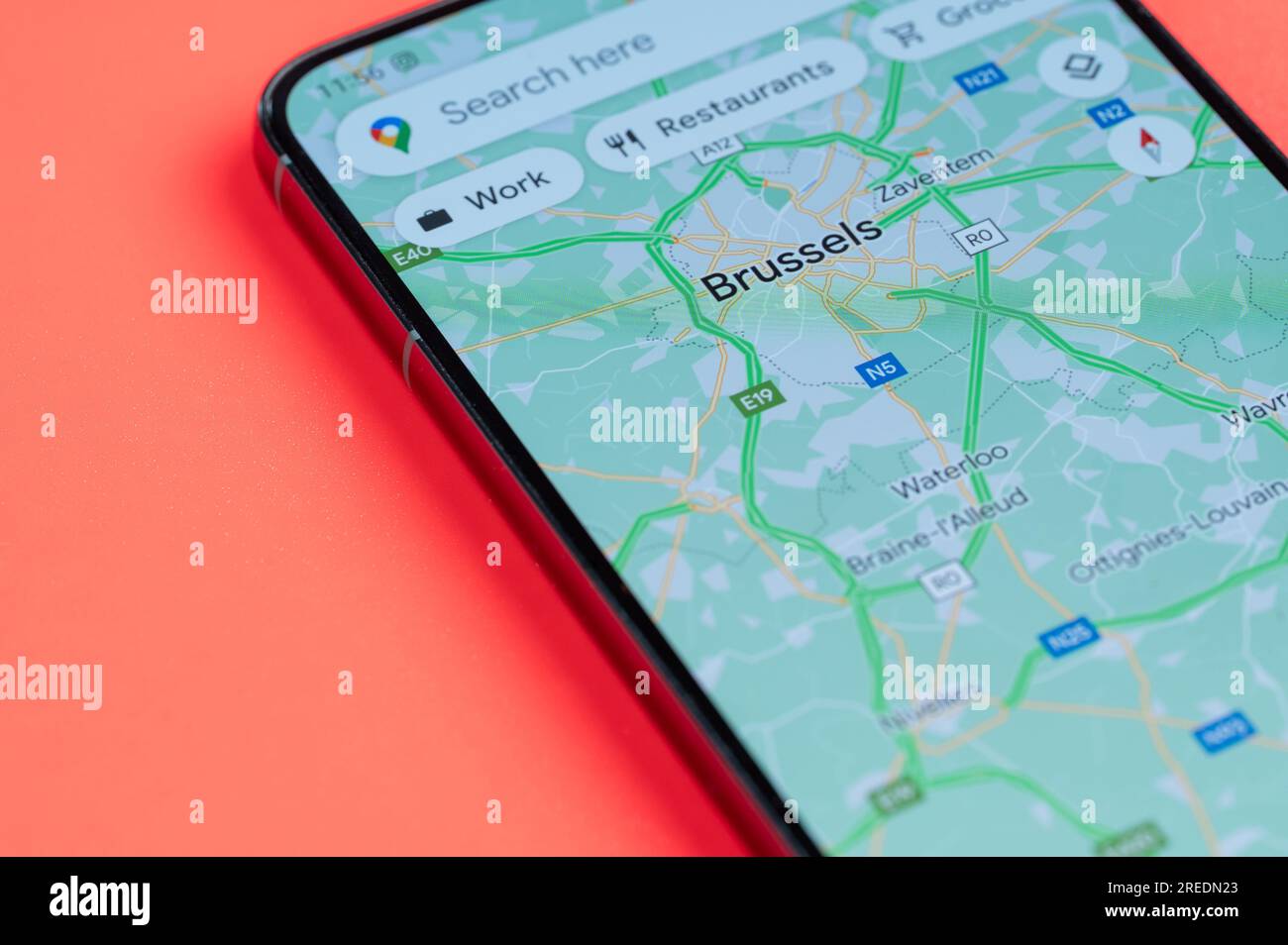 New York, États-Unis - 21 juillet 2023 : faire le meilleur itinéraire à travers les embouteillages à Bruxelles sur l'écran de smartphone vue rapprochée avec fond rouge Banque D'Images