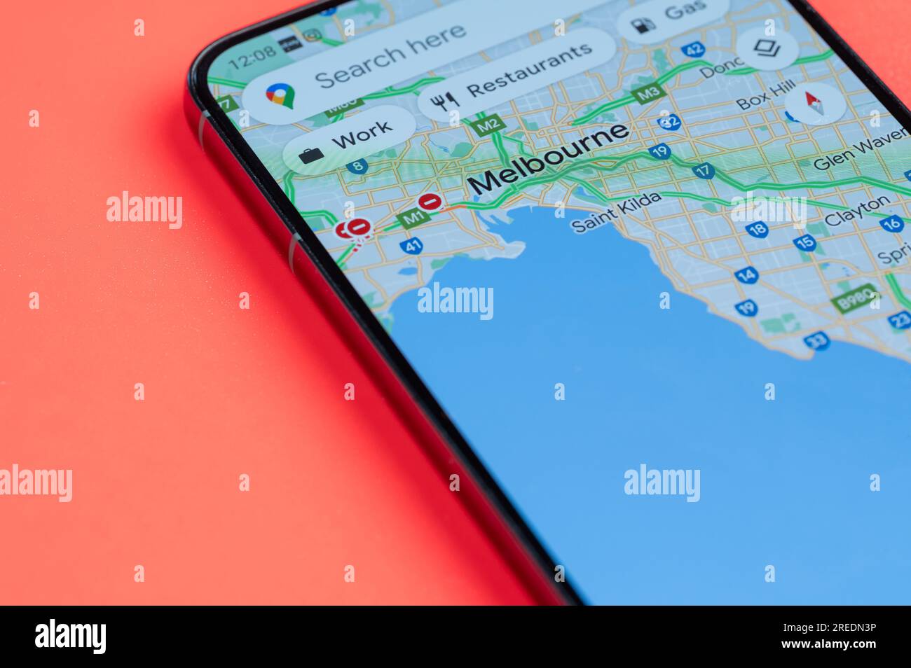 New York, États-Unis - 21 juillet 2023 : Melbourne distribution du trafic automobile dans google maps sur écran smartphone vue rapprochée avec fond rouge Banque D'Images