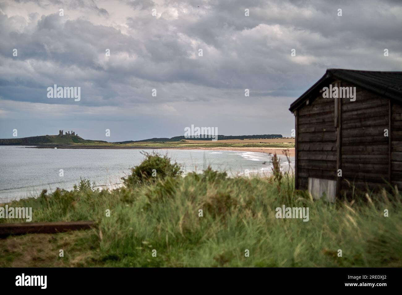 Ce bungalow de vacances se trouve sur les dunes de sable d'Embleton Bay dans le Northumberland et offre une vue sur le château de Dunstanburgh Banque D'Images