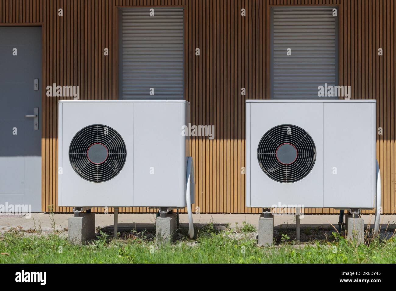 Vue frontale de deux pompes à chaleur à source d'air, un système de chauffage écologique, installé dans une propriété résidentielle moderne. Banque D'Images
