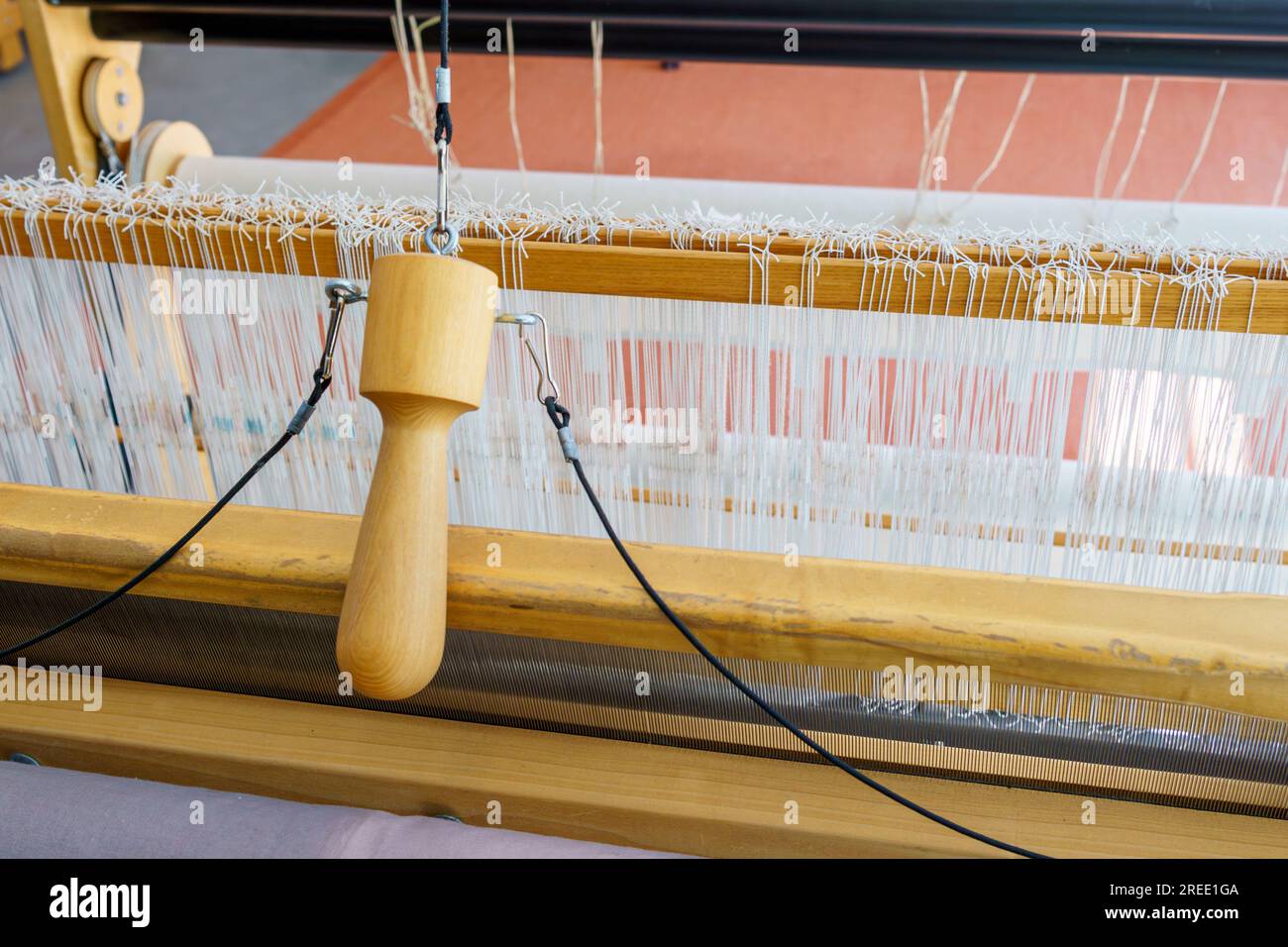 Gros plan de fils de traction et de chaîne de navette volante d'un métier à tisser de sol pour le tissage de textiles Banque D'Images