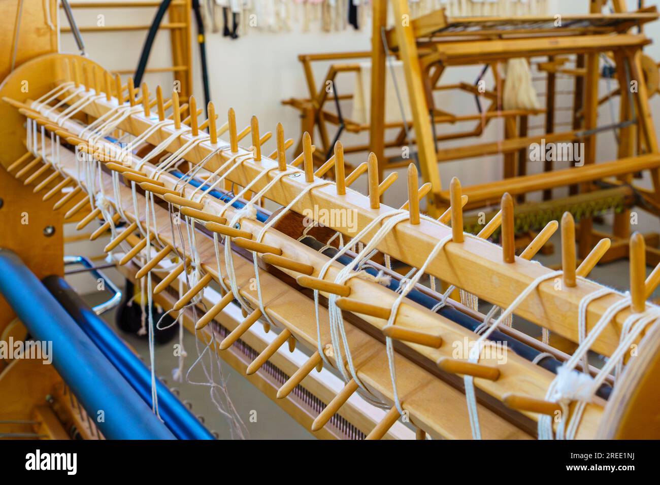 Gros plan de chevilles de gauchissement sectionnelles d'un métier à tisser dans un atelier de tissage de textiles Banque D'Images