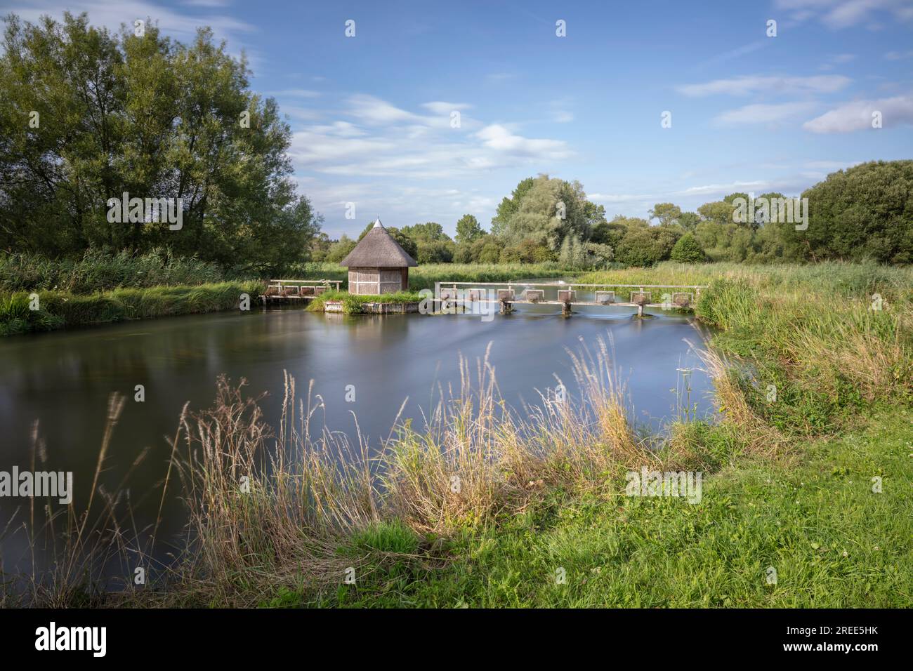 La rivière Test et cabane de pêcheur en chaume avec cages à anguilles, Longstock, Test Valley, Hampshire, Angleterre, Royaume-Uni, Europe Banque D'Images