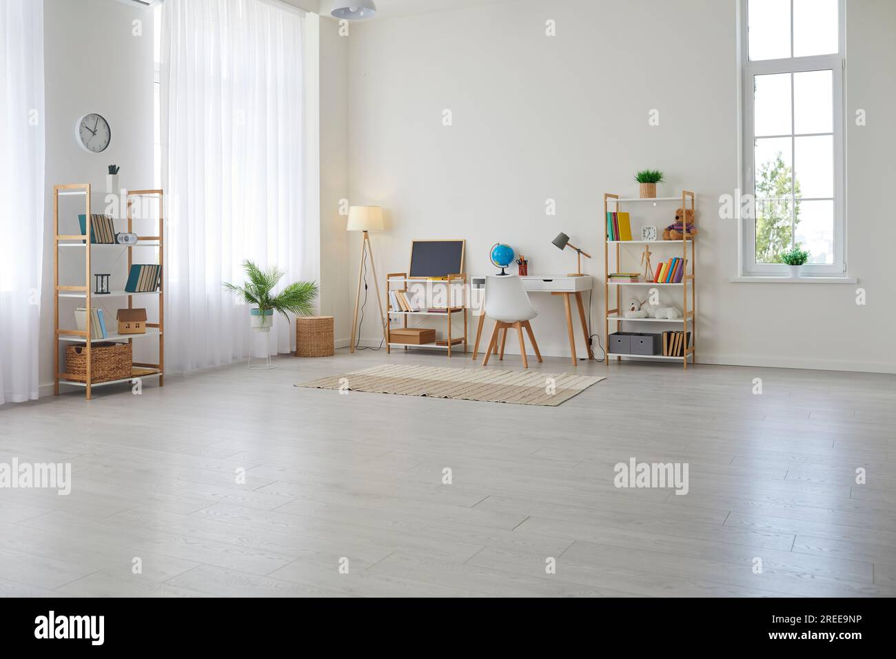 Chambre d'enfants avec bureau d'étude, chaise, étagères, tableau noir, lampes, plantes et tapis Banque D'Images