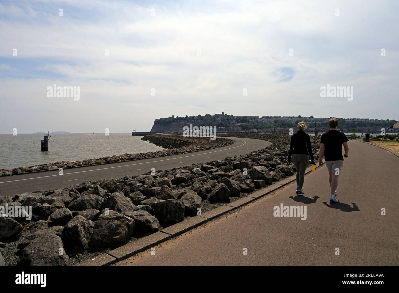 Jeune couple marchant le long du barrage de Cardiff sur le Cardiff Bay Trail. Cardiff. Juillet 2023 Banque D'Images