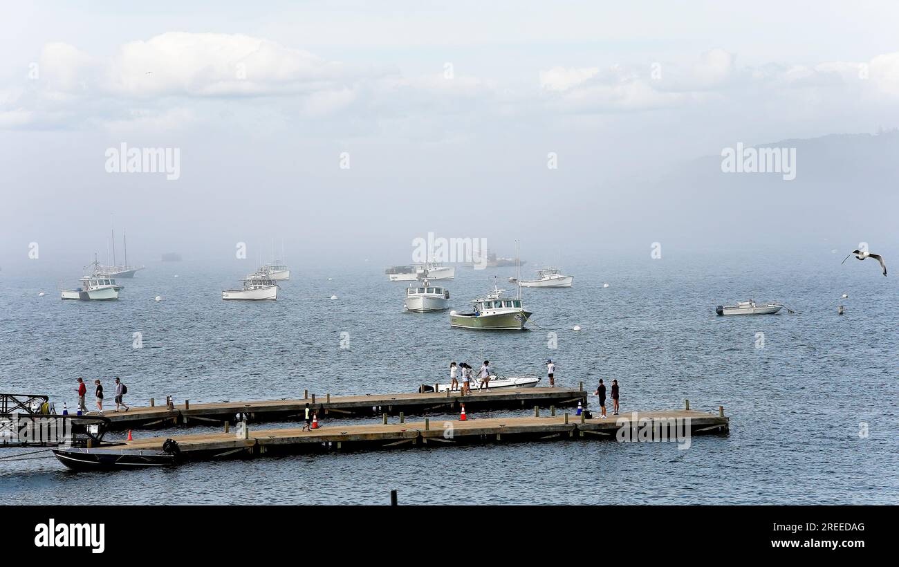 BAR HARBOR, MAINE, États-Unis - 9 JUILLET 2023 : bateaux amarrant à Bar Harbor avec touriste sur la plate-forme en bois enjouant le brouillard et la belle journée Banque D'Images