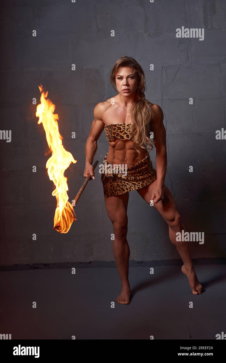 Chasseur préhistorique féminin musclé stadning avec une torche enflammée  Photo Stock - Alamy
