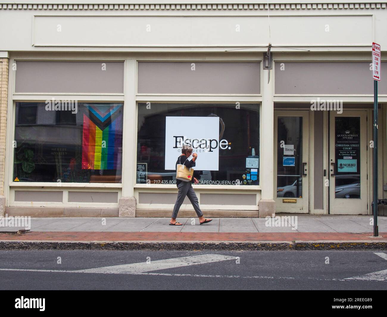 Femme piétonne passant par Escape on Queen escape room business, Lancaster, Pennsylvanie, 5 juin 2023, © Katharine Andriotis Banque D'Images