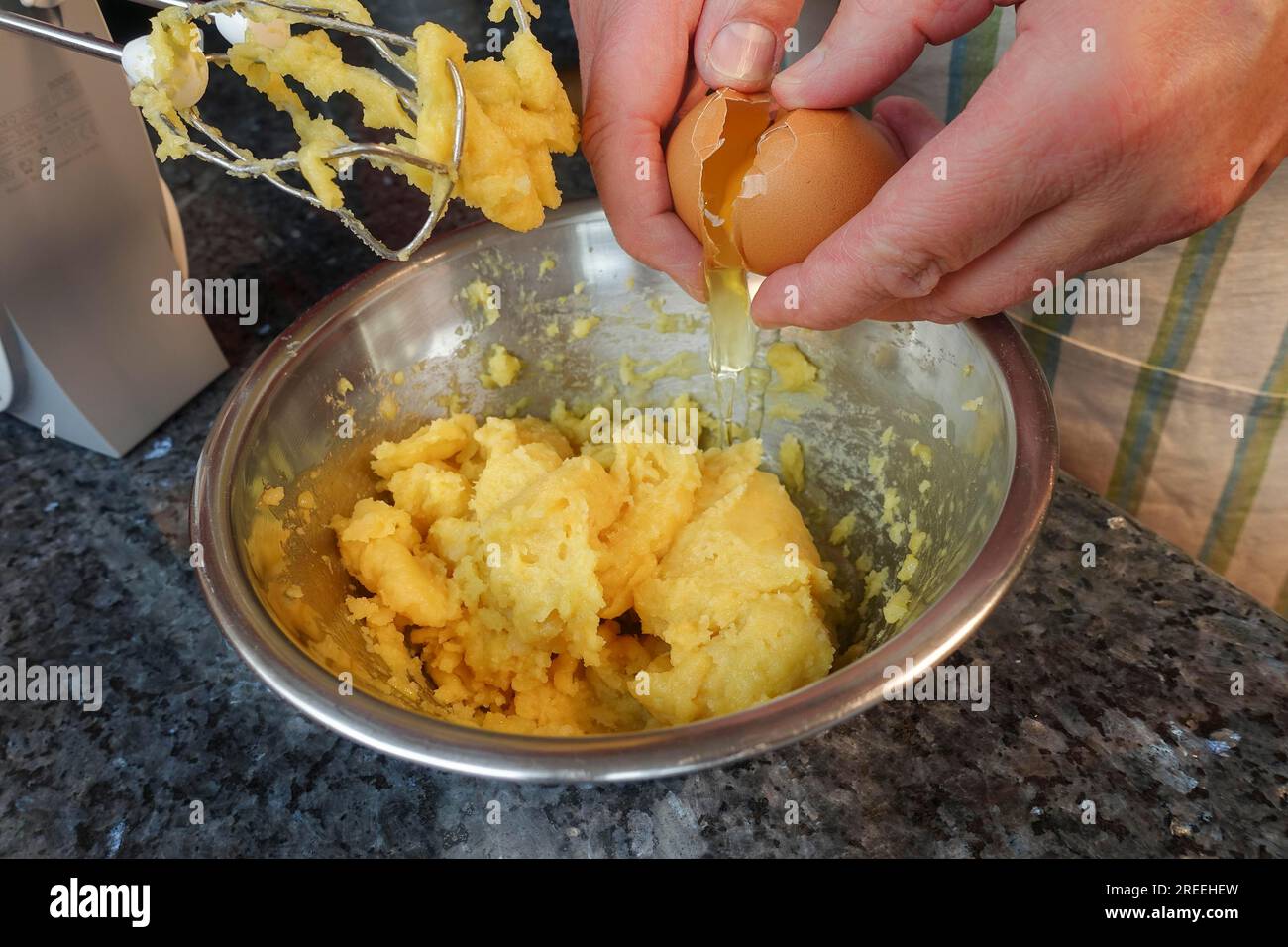 Cuisine souabe, préparation de pâte à choux pour les mini choux à la crème, ajout d'œufs à la pâte à choux crue, fouettage, fouettage dans la casserole, fouettage d'œufs, éclairs Banque D'Images