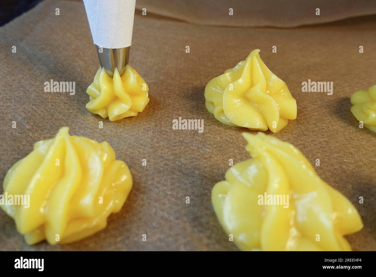 Cuisine souabe, préparation de minibouffées à la crème, presser la pâte à choux crue à travers