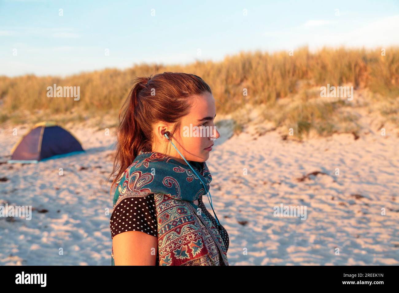 Portrait d'une femme avec des écouteurs à la plage Banque D'Images