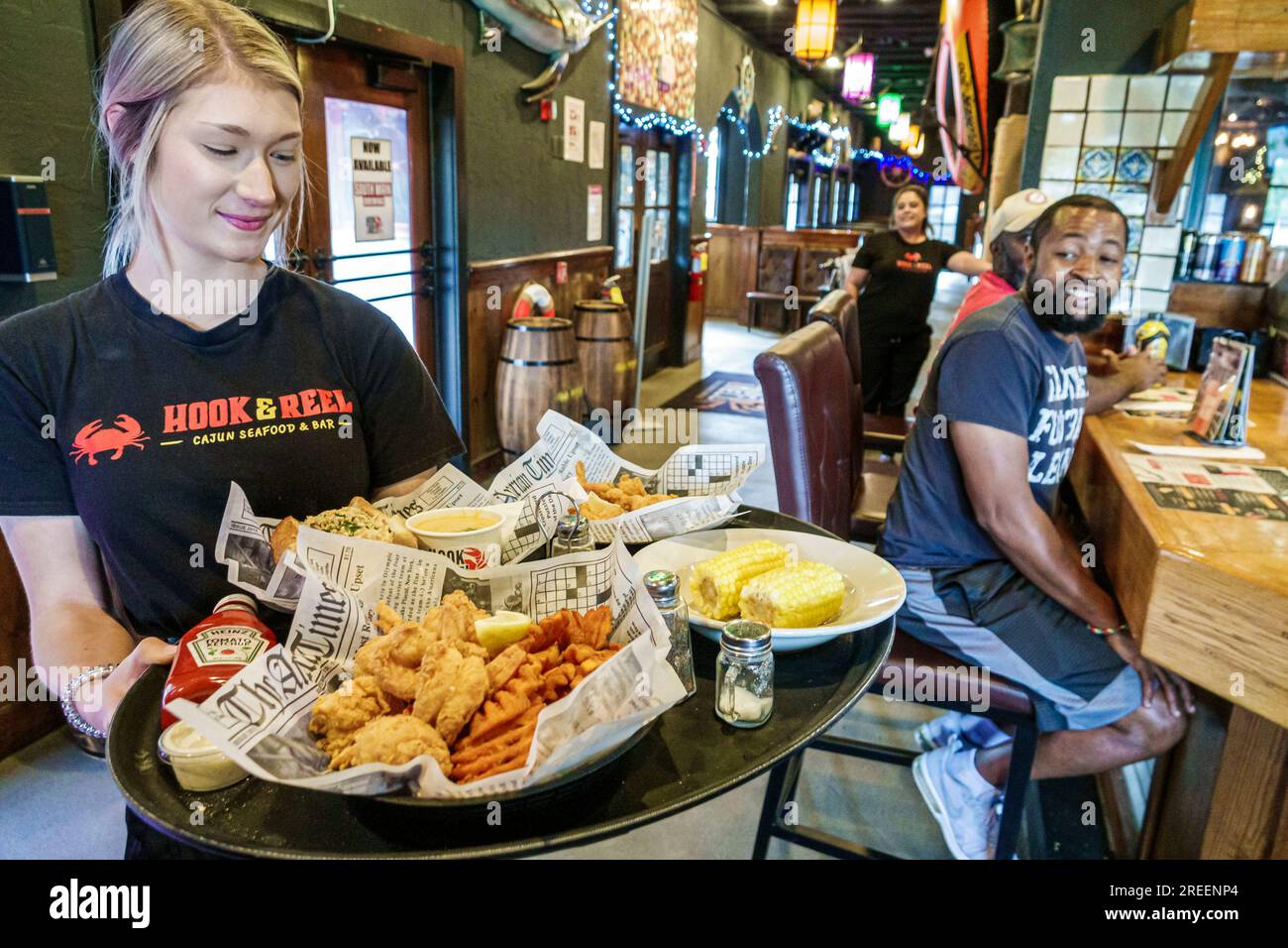 Athens Géorgie, Hook & Reel Cajun Seafood and Bar Restaurant, intérieur intérieur à l'intérieur, serveuse de serveur, servant le déjeuner sur commande, poisson frit gaufres frites maïs c Banque D'Images