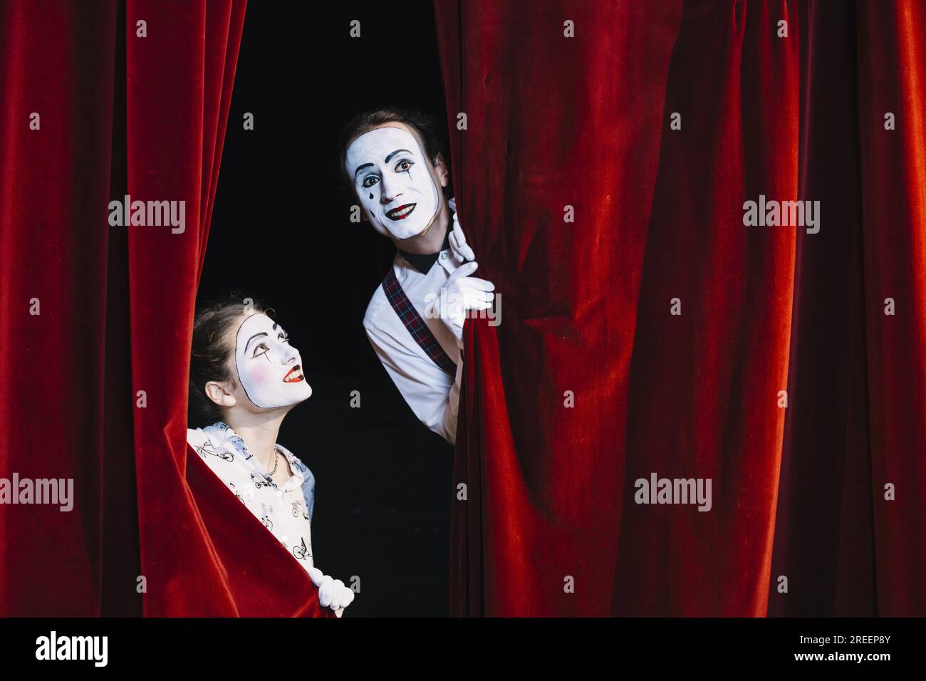 Souriant artiste mime féminin regardant artiste mime masculin regardant du rideau. Résolution et haute qualité belle photo Banque D'Images