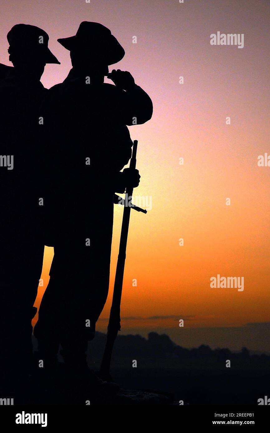 Le soleil se lève sur le Virginia Memorial, créant des silhouettes des sculptures des soldats de la guerre de Sécession sur le champ de bataille national de Gettysburg Banque D'Images