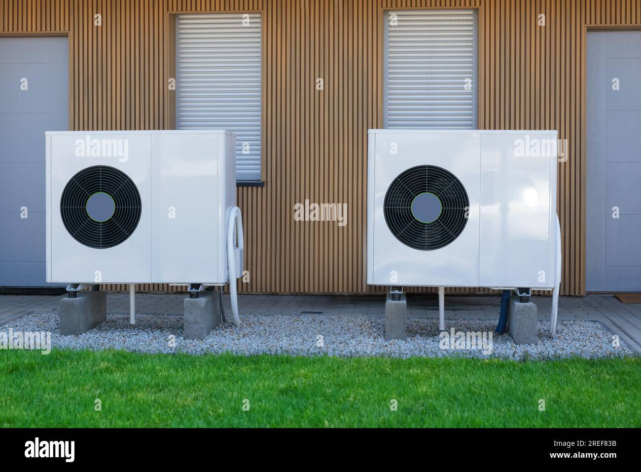 Deux pompes à chaleur à source d'air à haut rendement installées à l'extérieur d'une maison contemporaine, utilisant l'électricité verte pour un soluti de chauffage durable Banque D'Images