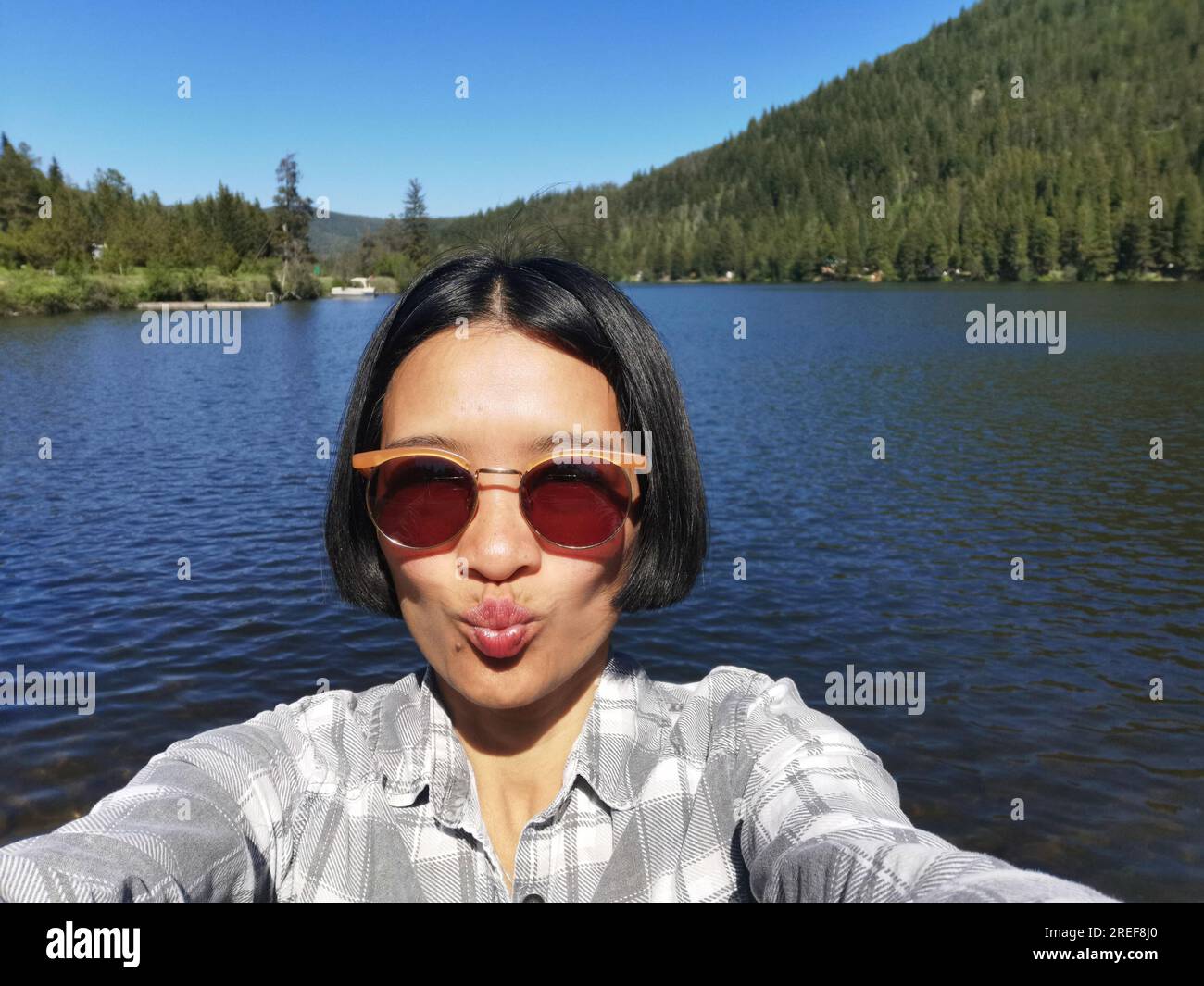 Femme asiatique prenant un selfie au site récréatif de Chain Lake West, situé sur Princeton Summerland Highway, Colombie-Britannique, Canada. Banque D'Images