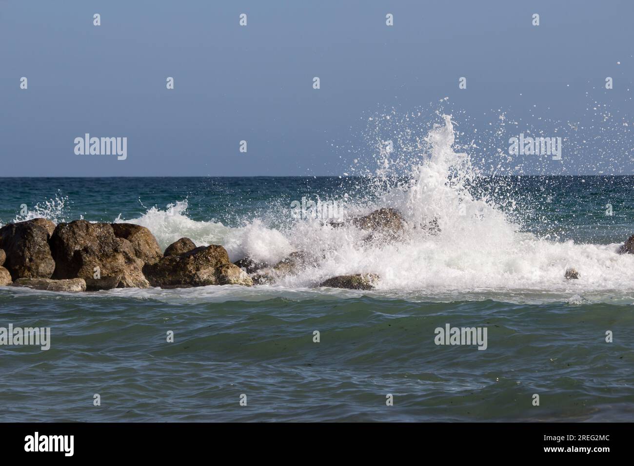 Vague se brisant sur les rochers avec l'horizon en arrière-plan Banque D'Images