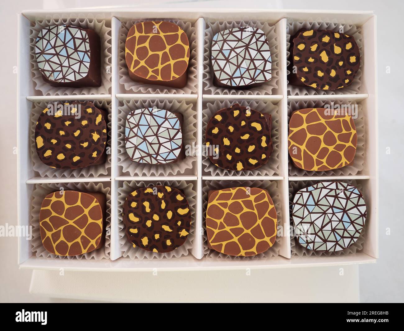 chocolats artisanaux décorés de motifs géométriques dans une boîte cadeau Banque D'Images